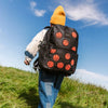 boy walks through a meadow wearing his state bags kane kids double pocket backpack in fuzzy basketballs